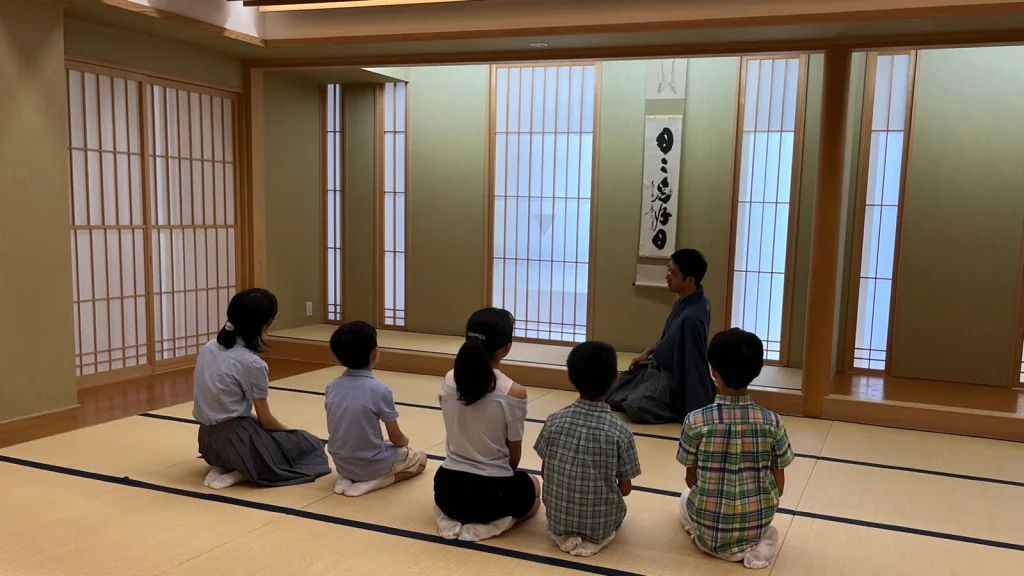 としま区民センターの和室で、講師の説明を聞く子ども茶道体験会の参加者