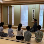 としま区民センターの和室で、講師の説明を聞く子ども茶道体験会の参加者