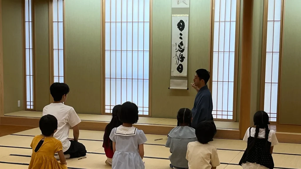 としま区民センターの和室で、講師の説明を聞く子どもたちの後ろ姿