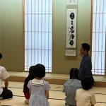 としま区民センターの和室で、講師の説明を聞く子どもたちの後ろ姿