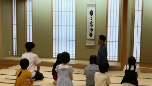 としま区民センターの和室で、講師の説明を聞く子どもたちの後ろ姿