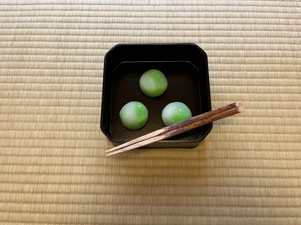 畳の上に置かれた緑と白の季節の和菓子。銘：薫風（源太製）