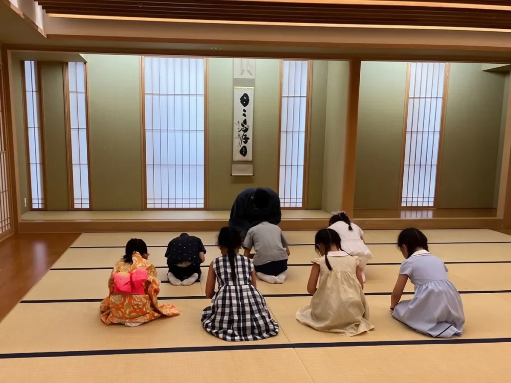 子ども茶道体験会で、講師と子どもたちが畳の上でお辞儀をしている様子