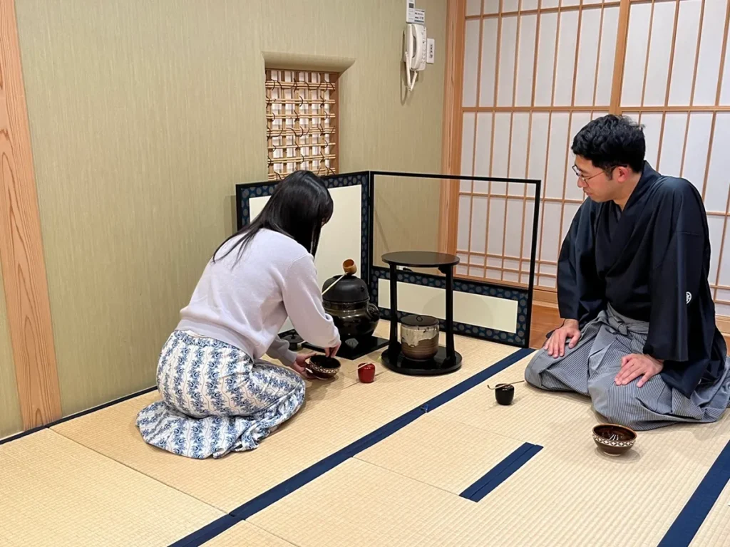 喫茶去で、講師に見守られながら薄茶を点てる参加者
